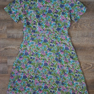 May include: A vintage floral print dress with a V-neckline and short sleeves. The dress is made of a lightweight fabric and has a flowing silhouette.