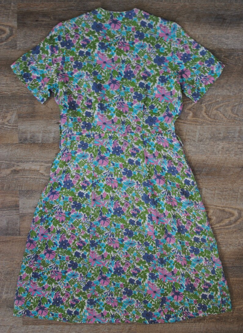 May include: A vintage floral print dress with a V-neckline and short sleeves. The dress is made of a lightweight fabric and has a flowing silhouette.