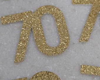 May include: Gold glitter number 70 cutouts. The numbers are on a white background.