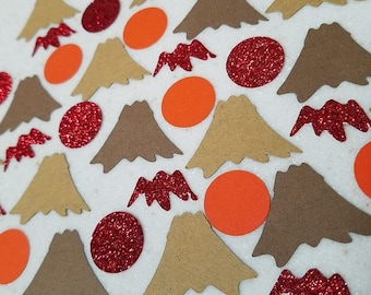 May include: A collection of brown and tan paper cutouts of mountains, red glitter circles, and orange circles. The circles are scattered on a white surface.