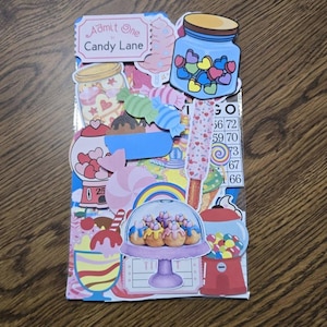 May include: A colorful collage featuring various candy-themed illustrations. The design includes images of candy jars, gumball machines, lollipops, and cupcakes. The text "Admit One to Candy Lane" is visible at the top. The overall theme is a whimsical and playful design.