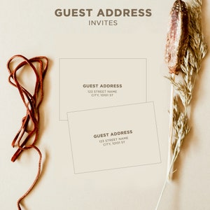 May include: Two white cards with brown text that reads "GUEST ADDRESS" followed by an address. The cards are on a beige background with a brown leather cord and a dried flower stalk.