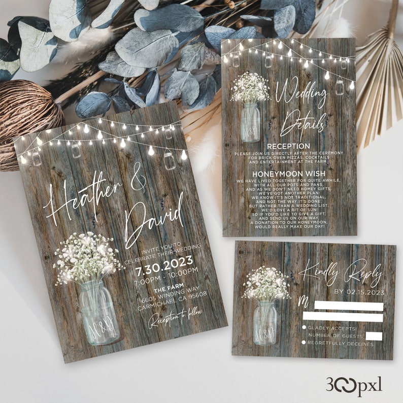 A rustic wedding invitation set featuring a grey wooden background with glowing fairy lights, a mason jar, and delicate baby’s breath flowers. Perfect for country, barn, or outdoor weddings.