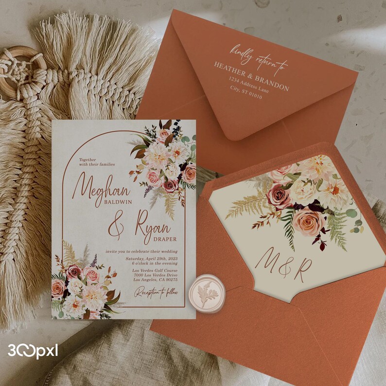 A terracotta boho wedding invitation with matching burnt orangeenvelopes, envelope liner, wax seal and address printing