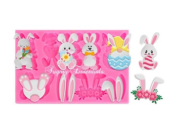 May include: Pink silicone mold with multiple Easter bunny designs. The mold includes bunnies holding flowers, a bunny with a bow tie, a bunny in an egg, and bunny ears. The mold also includes a floral design.