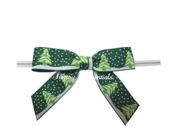 May include: A green and white ribbon bow with a Christmas tree pattern. The bow is tied around a white wire.