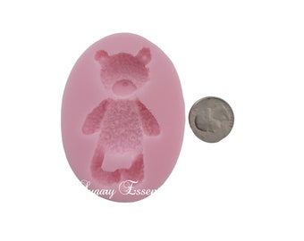May include: A pink silicone mold in an oval shape featuring a teddy bear design. A silver coin is next to the mold for size comparison. The mold is for crafting or baking.
