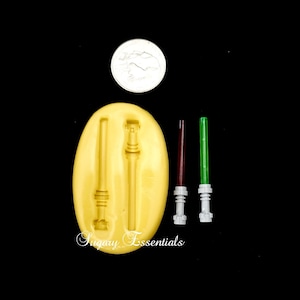 May include: A silicone mold for making lightsaber candy. The mold has two lightsaber shapes and is shown next to three finished lightsabers, one red, one green, and one gray.