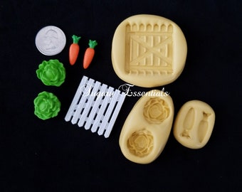 May include: A collection of silicone molds and finished pieces including a round gate mold, a small oval mold for lettuce and carrots, two green lettuce pieces, two orange carrots, a white picket fence piece, and a US quarter for scale.