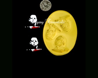 May include: Yellow silicone mold with three Halloween-themed designs. The mold features a design of Michael Myers from the Halloween franchise, with a knife, and two other masked figures.