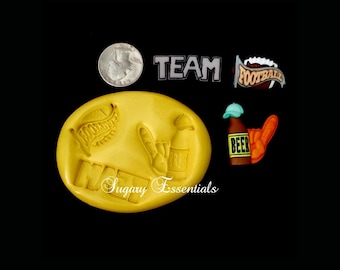 May include: A yellow silicone mold with the words "Game Day" and images of a football, beer bottle, and a hand giving a thumbs up. There are also separate silicone molds for the words "Team" and "Football".