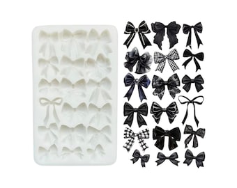 May include: A rectangular white silicone mold featuring multiple cavities shaped like various bows, accompanied by a display of twenty-one distinct black bow designs, including solid, checkered, lace, and embellished styles, arranged in a grid.