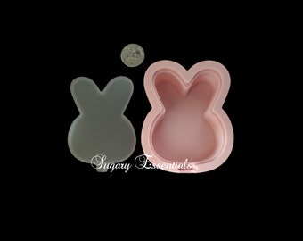 May include: A pink silicone mold shaped like a bunny rabbit. The mold is open and the inside is visible. The mold is about the size of a US quarter.