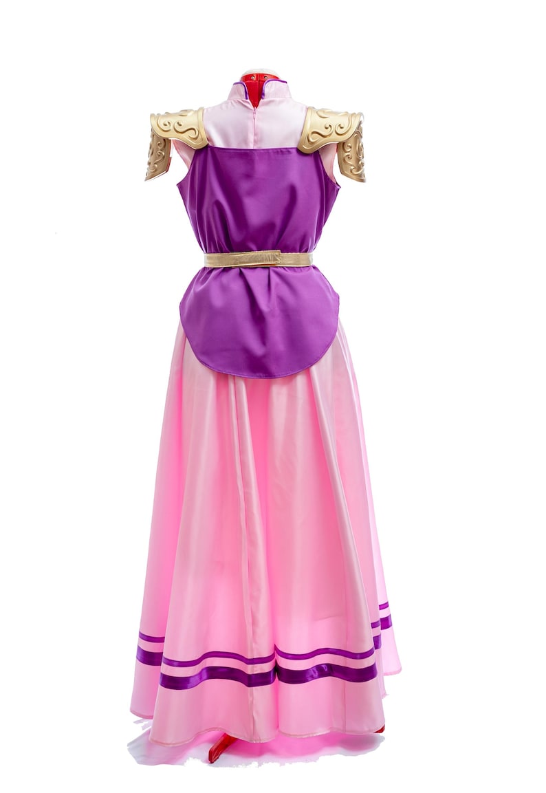 Puede incluir: Un disfraz de cosplay con un vestido rosa y morado con detalles dorados. El vestido tiene un cuello alto, un corpi&ntilde;o morado y una falda larga y fluida de color rosa. Hombreras doradas y un cintur&oacute;n dorado completan el look.