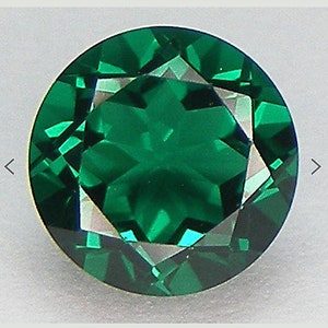 Peut inclure: Une pierre précieuse ronde, facetée, de couleur verte avec un motif en forme d'étoile au centre.