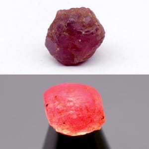 Puede incluir: Una piedra preciosa de rubí en bruto de color rojo intenso con una textura superficial facetada e irregular. La piedra muestra un tono carmesí oscuro con luz natural y un aspecto rosa neón brillante cuando se ilumina desde abajo.