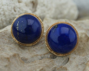 Könnte beinhalten: Ein Paar goldene Ohrringe mit runden, blauen Lapislazuli-Steinen, die in einer goldenen, seilartigen Fassung gefasst sind.