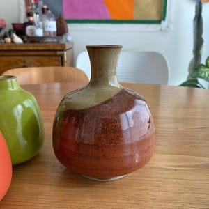 A handmade ceramic vase with a rounded body and a narrow neck.