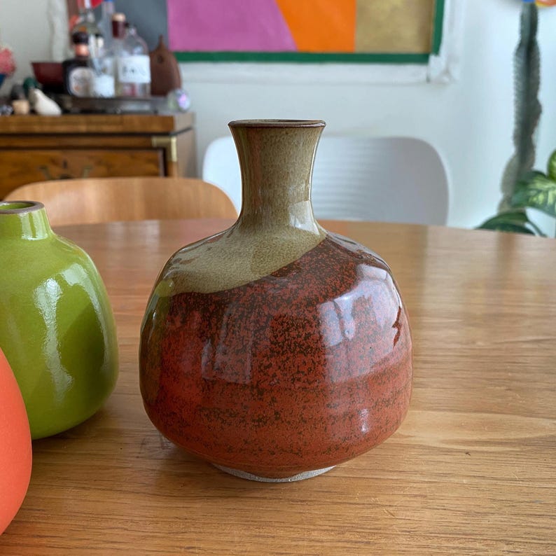 A handmade ceramic vase with a rounded body and a narrow neck.