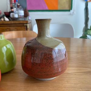 A ceramic vase with a rounded body and a narrow neck.