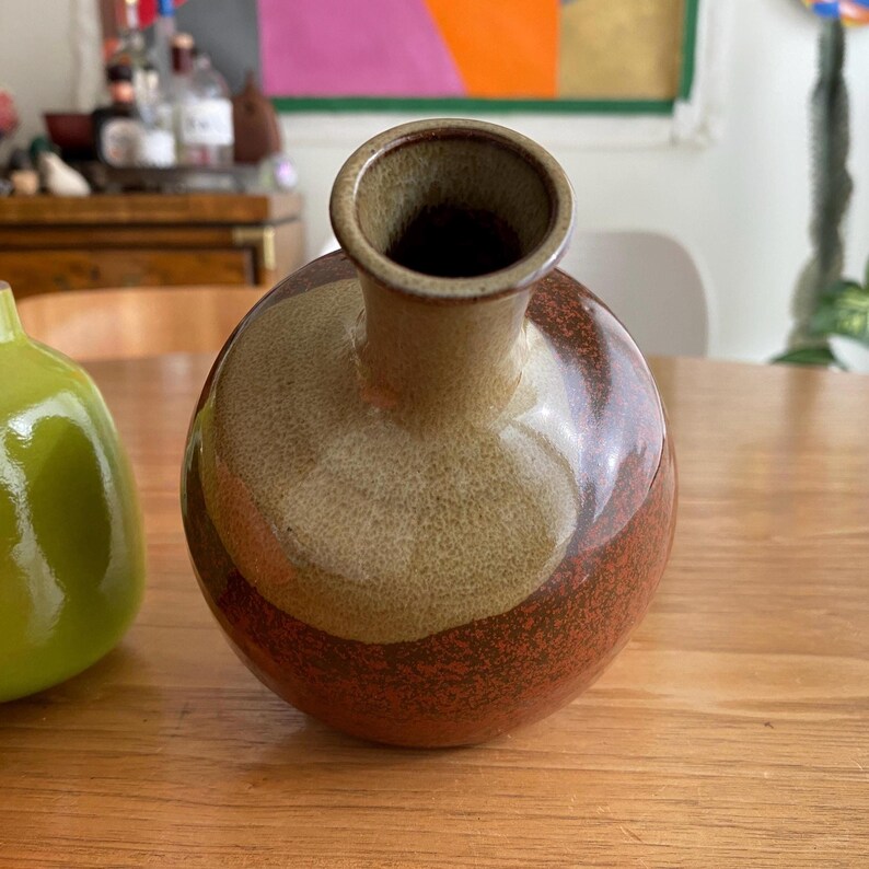 A ceramic vase with a round body and a narrow neck.