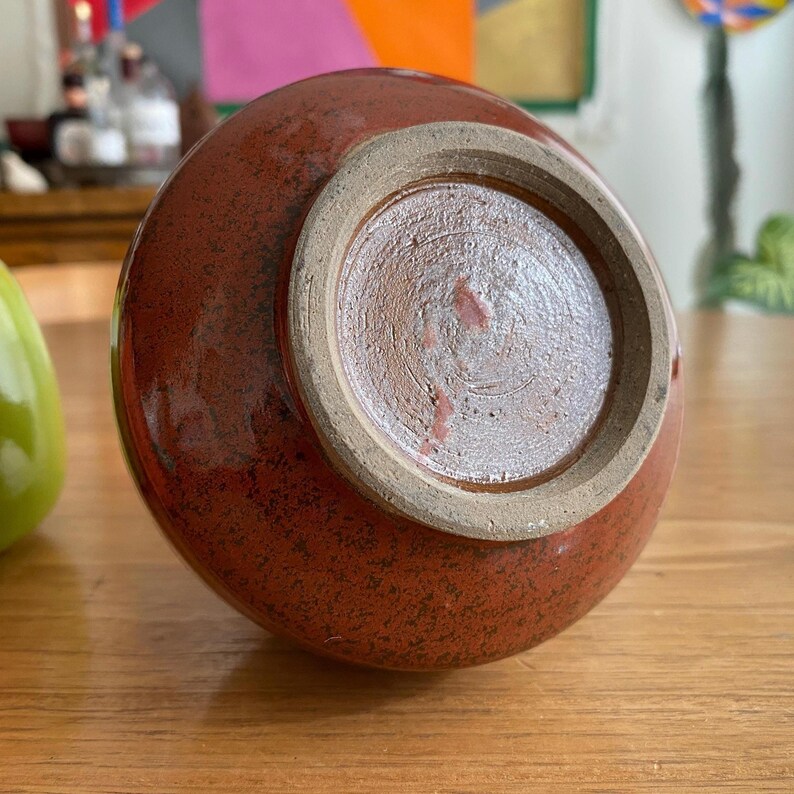 A handmade, red-brown ceramic vase.