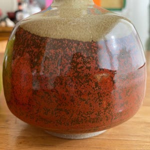 A handcrafted ceramic vase with a rounded body and a narrow neck.