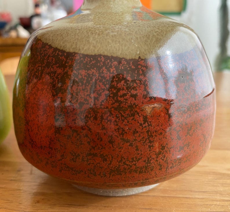A handcrafted ceramic vase with a rounded body and a narrow neck.
