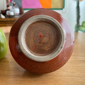 A round, reddish-brown ceramic vase.