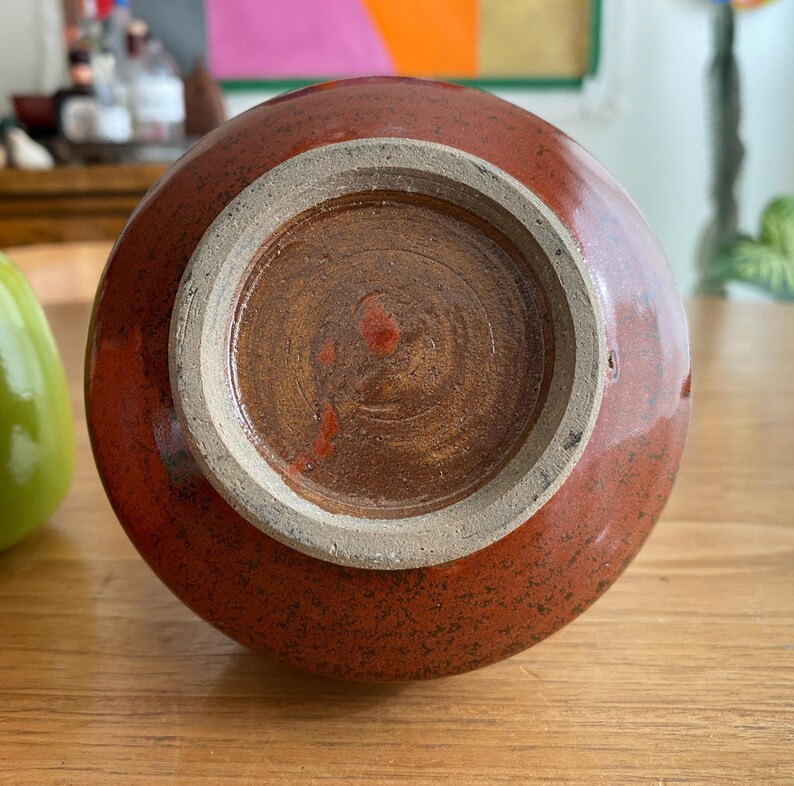 A round, reddish-brown ceramic vase.