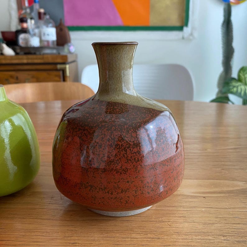 A handcrafted ceramic vase with a rounded body and a narrow neck.