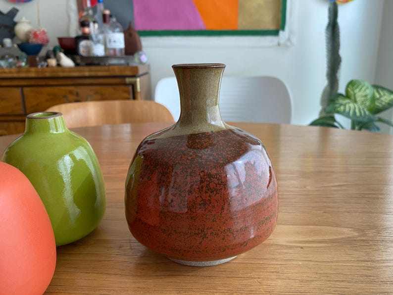 A ceramic vase with a rounded body and a narrow neck.