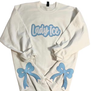 Besticktes Side Bow Sweatshirt mit Glitzer “Lady Ice”, Trendy Side Bow Applikation, Coquette Style Bow Sweatshirt, Team Spirit Sweater