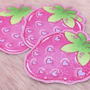 May include: Three pink glitter strawberry stickers with a green leaf and white hearts.