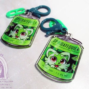 Op de afbeelding: Twee groene en witte acrylcharms in de vorm van een blikje frisdrank. Het blikje heeft een cartoonkattengezicht erop en de tekst "SPRIGATEQUILA Tequila margarita cocktail 10.6% ABV 7.5 FL.OZ". Elke charm heeft een groene en blauwe metalen clip.