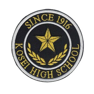 May include: A black and white embroidered patch with a gold star and laurel wreath. The text "KOSEI HIGH SCHOOL SINCE 1916" is written around the star.