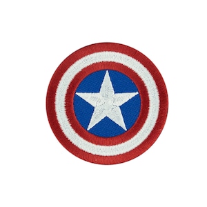 May include: A red, white, and blue embroidered patch featuring a white star on a blue circle surrounded by concentric white and red circles.