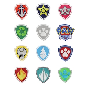 May include: A collection of twelve shield-shaped embroidered patches featuring various icons including an anchor, star, propeller, recycling symbol, paw print, wrench, tree, flame, and the Paw Patrol logo in vibrant colors like red, blue, yellow, and green.
