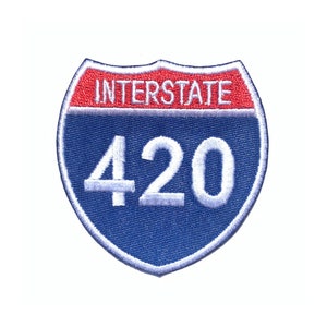 May include: A blue and red interstate highway sign with the number 420.