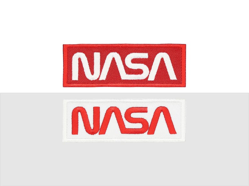 Pu&ograve; includere: Due toppe NASA. Una toppa ha uno sfondo rosso con testo ricamato bianco. L'altra toppa ha uno sfondo bianco con testo ricamato rosso. Entrambe le toppe sono rettangolari.