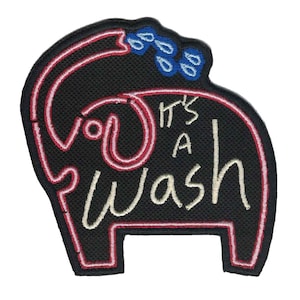 May include: A black embroidered patch with a red outline of an elephant with the text "It's a wash" in white. The elephant has a pink outline and blue water droplets above it.