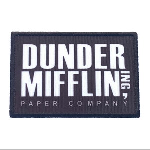 May include: Black and white embroidered patch with the text "Dunder Mifflin, Inc. Paper Company" in white lettering.