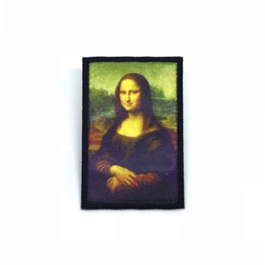 May include: A black framed embroidered patch featuring a reproduction of the Mona Lisa painting.