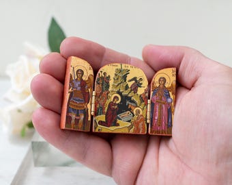 Miniaturowa drewniana ikona tryptykowa z narodzeniem Jezusa Chrystusa i archaniołami Michałem i Gabrielem po bokach. Grecka ikona chrześcijańska,
