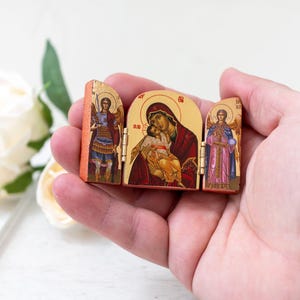 Icono tríptico de madera en miniatura con la Virgen María y los santos Miguel y Gabriel a sus lados derecho e izquierdo, icono cristiano griego.