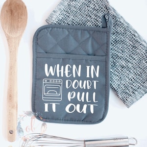 May include: Gray oven mitt with white text that reads "When in doubt pull it out". The text is accompanied by a small illustration of an oven.