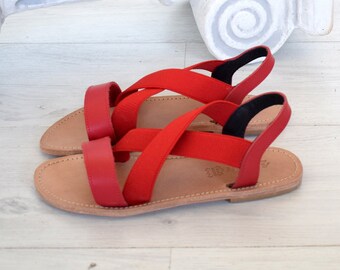 May include: Red leather sandals with criss-cross straps and a brown leather sole.