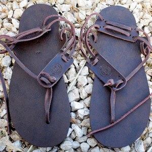 May include: A pair of brown leather sandals with adjustable straps and a simple design. The sandals are made of high-quality leather and are perfect for everyday wear.