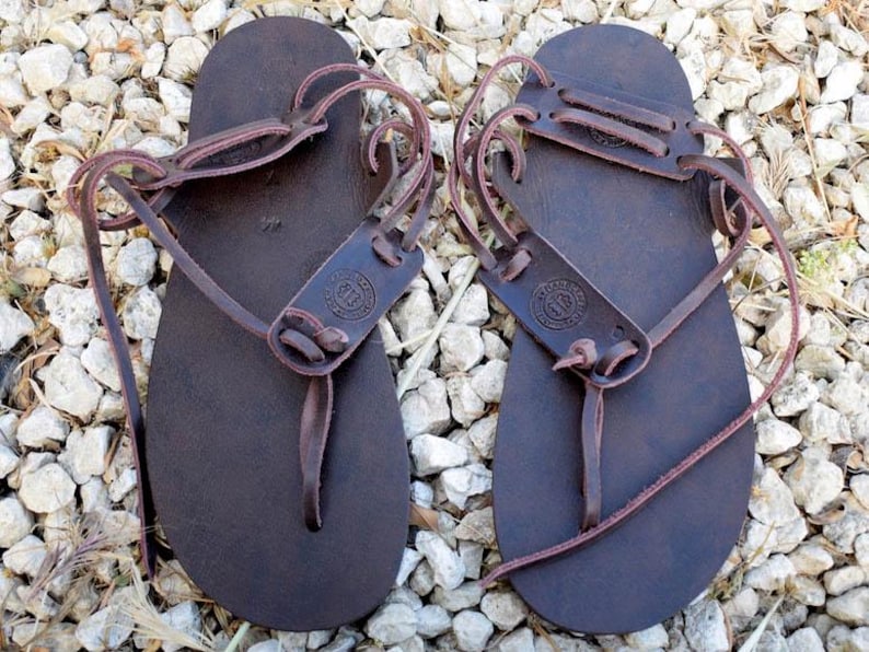 May include: A pair of brown leather sandals with adjustable straps and a simple design. The sandals are made of high-quality leather and are perfect for everyday wear.