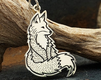 May include: A silver pendant in the shape of a fox curled up with its tail wrapped around its body. The fox is outlined in black and has a detailed, textured design.